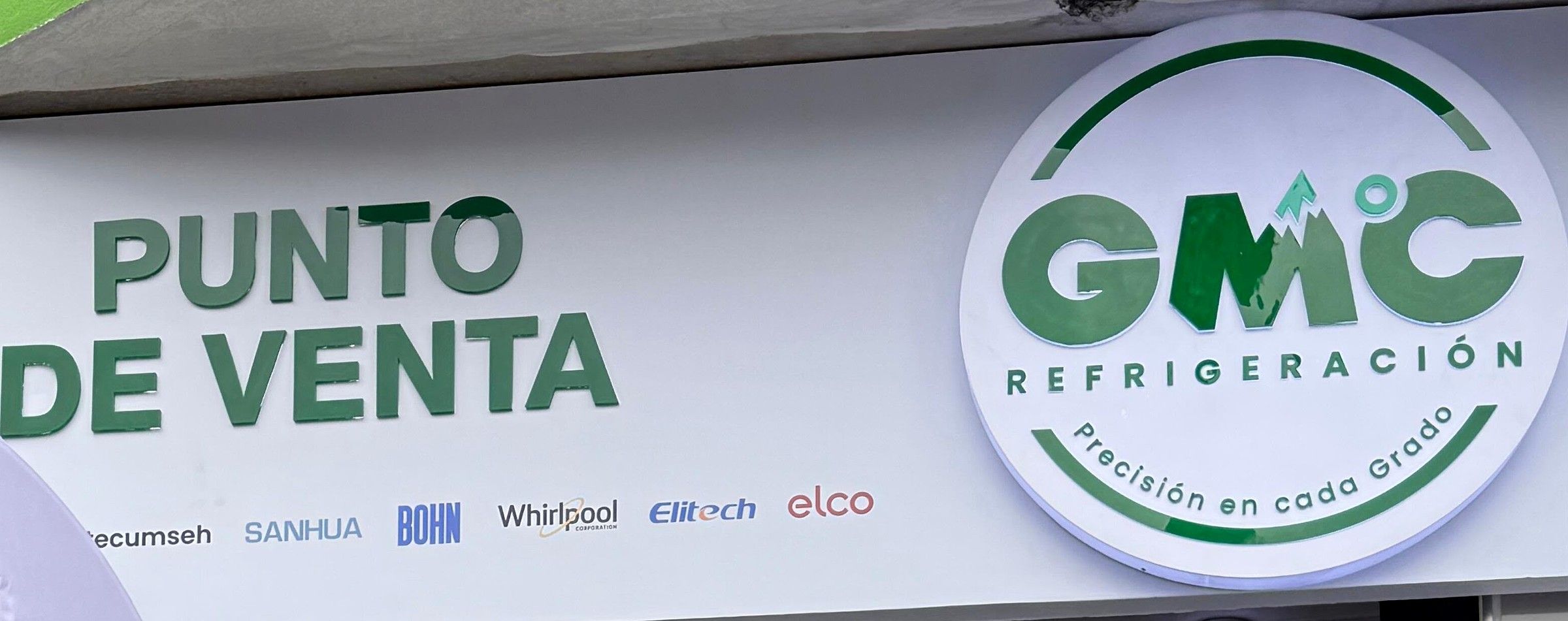 Aviso del punto de venta de GMC Refrigeración con el logo de la empresa y el lema Precisión en cada grado, sobre una franja de marcas de refrigeración